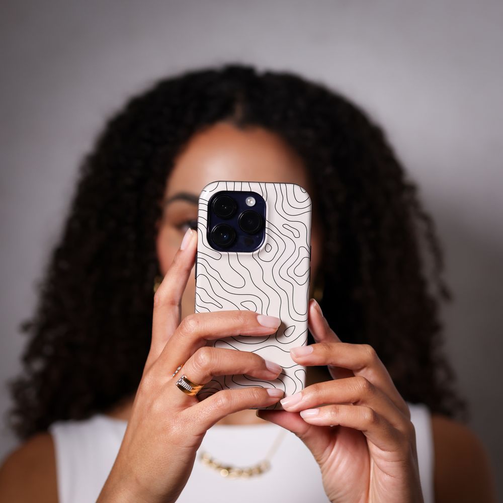 A creator filming content on a phone against a studio backdrop