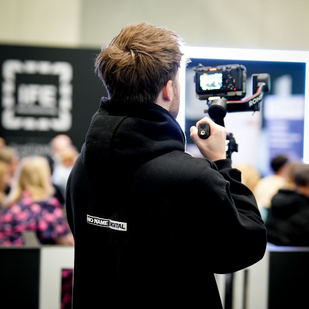 A No Name Digital videographer filming on a gimbal at a live event